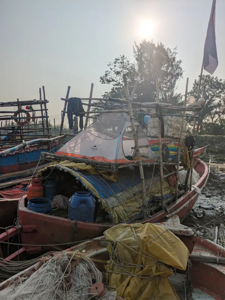 মাছধরা নৌকায় বাঁশের কাঠামো ও সরঞ্জামের মাঝে অভিযানের তাঁবু