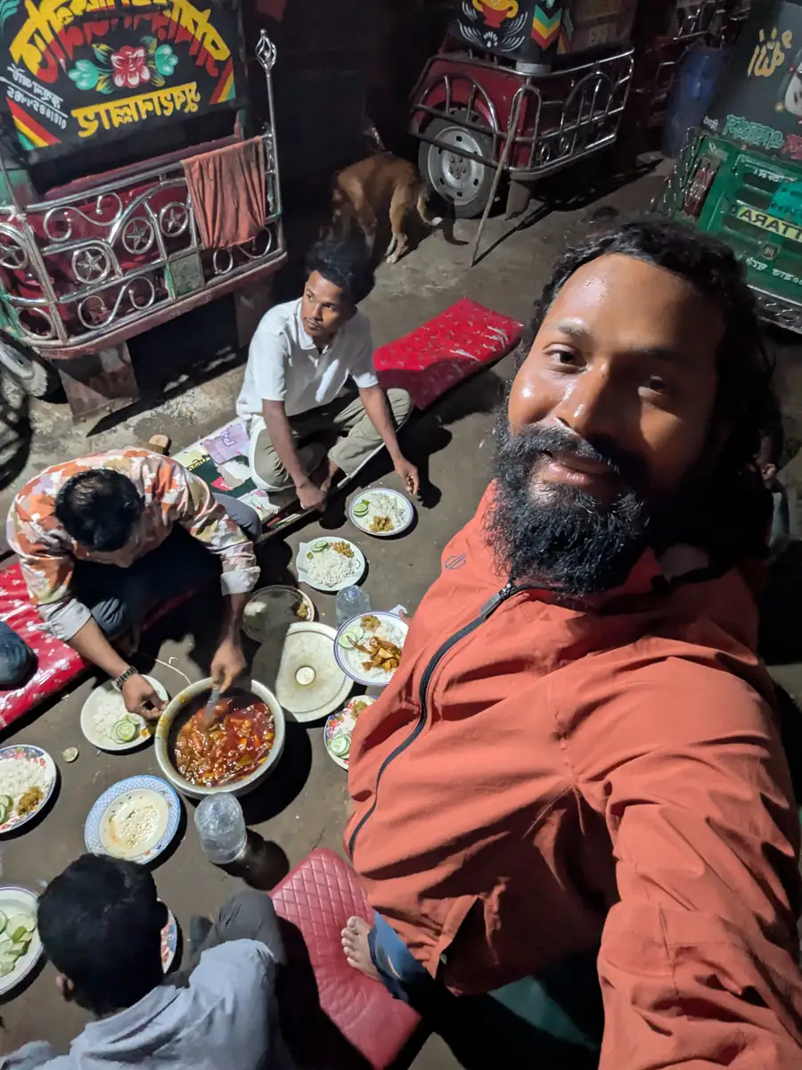 পার্ক করা অটোরিকশার মাঝে স্থানীয় মানুষদের সঙ্গে খেতে বসেছেন ইনতিয়াজ মাহমুদ