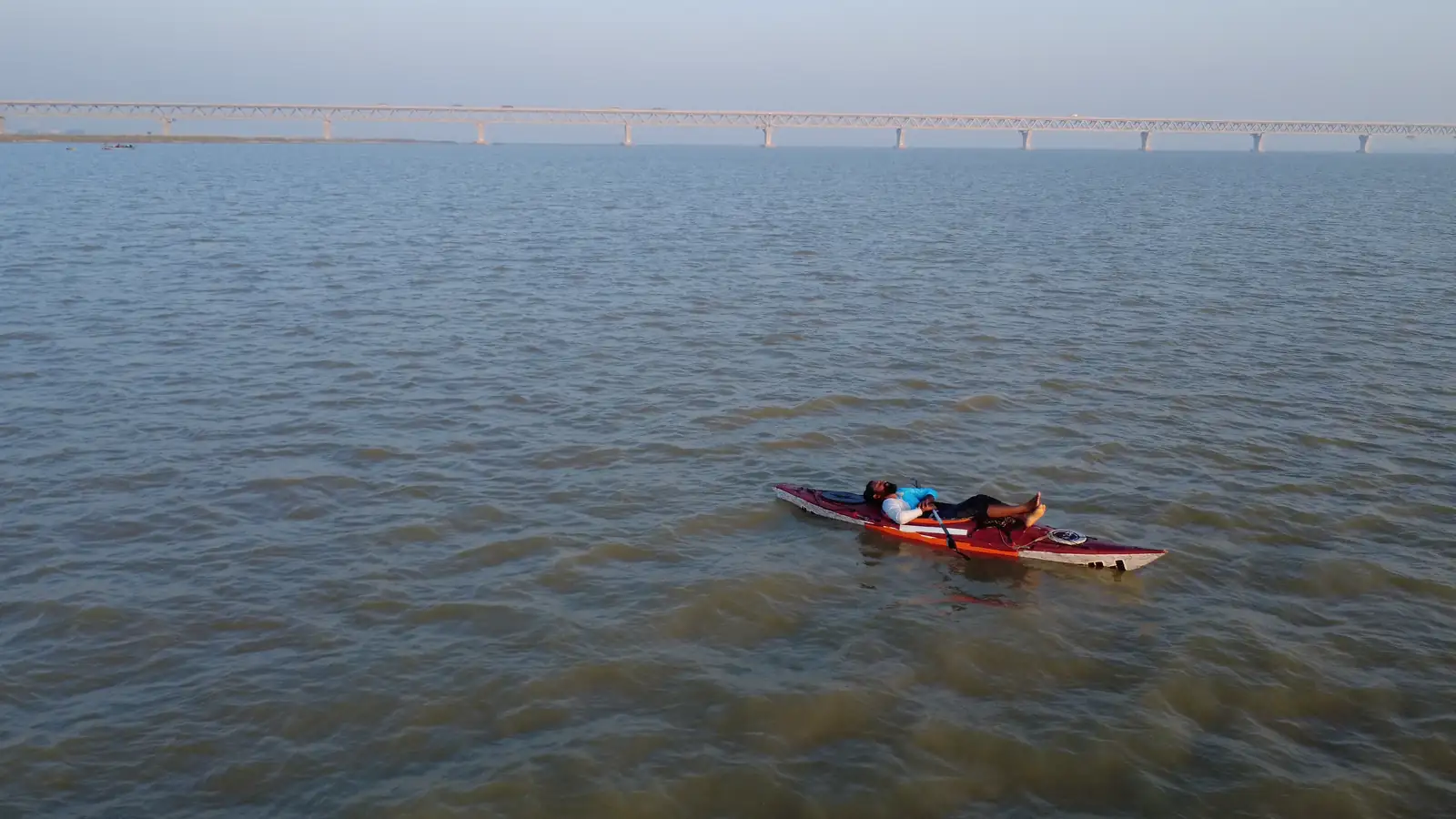 পেছনে পদ্মা সেতু, সামনে পদ্মার পানিতে কায়াকে বিশ্রাম নিচ্ছেন ইনতিয়াজ মাহমুদ