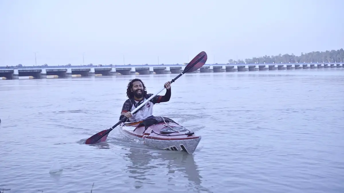 পেছনে তিস্তা ব্যারাজ রেখে কায়াকে বৈঠা চালাচ্ছেন ইনতিয়াজ মাহমুদ